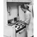 Young woman working in a kitchen Poster Print (18 x 24)