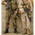 A Spanish Marine and a US Marine relax against a wall Poster Print by Stocktrek Images (22 x 34)