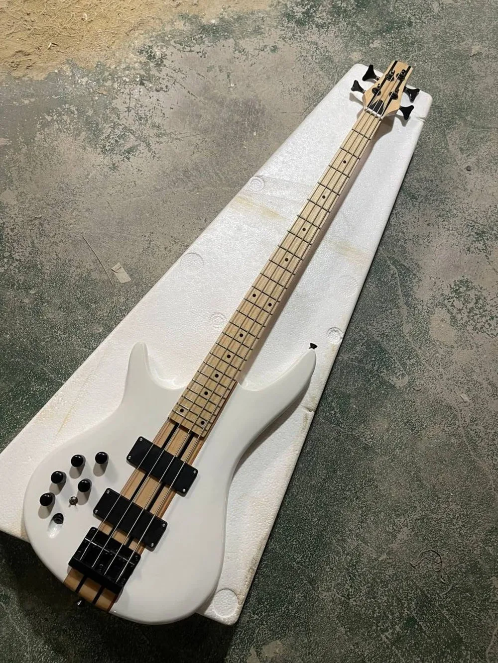 Weiße 4-saitige E-Bassgitarre mit Ahornhals, schwarzer Hardware, durchgehendem Hals am Korpus, bietet maßgeschneiderten Service. Image